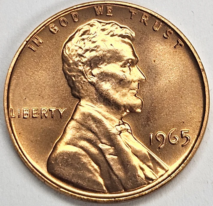 Side-by-side comparison of a regular 1965 penny versus a 1965 SMS Special Mint Set penny showing different surface finishes